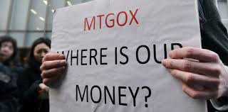A close-up shot of a person holding a protest sign that reads 'MTGOX WHERE IS OUR MONEY?' in front of the exchange's headquarters during the 2014 bankruptcy crisis.